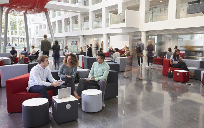 construction equipment dealers - Students talking in busy university campus building